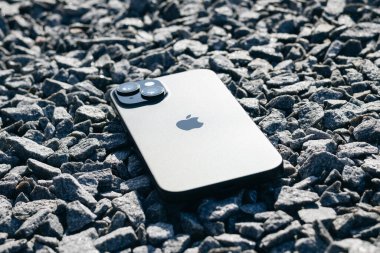 KYIV, UKRAINE - September 26, 2025 : Modern smartphone Apple iPhone on gray stones outdoors.