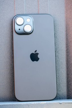 KYIV, UKRAINE - September 26, 2025 : Modern smartphone Apple iPhone on black iron background. Vertical photo.