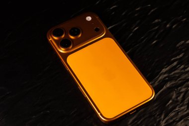 KYIV, UKRAINE - 22 Ocak 2026: Siyah arkaplanda Apple iPhone 17 Pro Kozmik Turuncu renk.