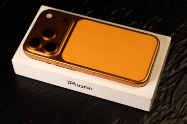 KYIV, UKRAINE - 22 Ocak 2026: Apple iPhone 17 Pro in Cosmic Orange renk kutusu siyah arkaplanda yatıyor.