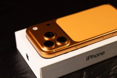 KYIV, UKRAINE - 22 Ocak 2026: Apple iPhone 17 Pro in Cosmic Orange renk kutusu siyah arkaplanda yatıyor.