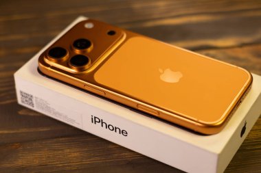 KYIV, UKRAINE - 22 Ocak 2026: Apple iPhone 17 Kozmik Turuncu renkli Pro tahta zemin üzerinde yer almaktadır.