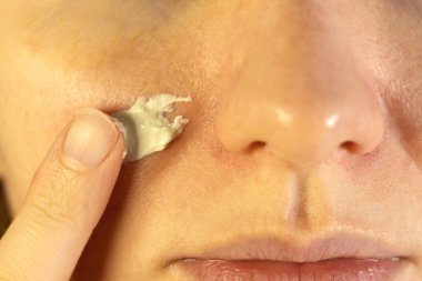 Yüzüne temizleyici maske takan bir kadın. Kapat..