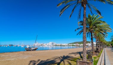Sahilde terk edilmiş yelkenli tekne. Sabah güneşi Ibiza sahildeki orta. St Antoni de Portmany Balearic Islands, İspanya için sahil boyunca sıcak güneşli gün