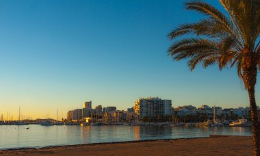 Golden sunset St Antoni de Portmany, bir koyda Balear Denizi plajında. Akşam şehre düşüyor.