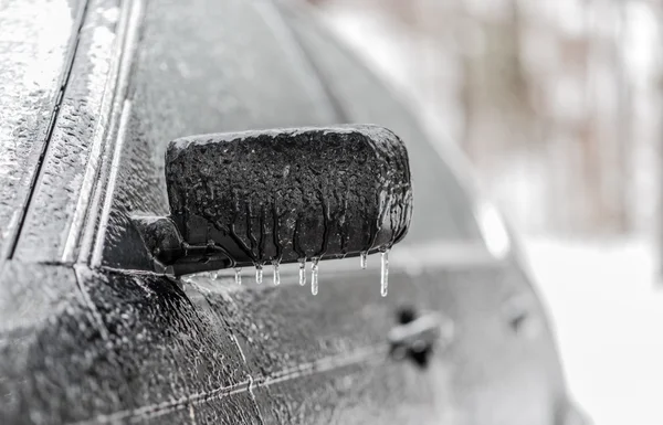 Βροχή πάγο με επικάλυψη αυτοκίνητο. Μαύρο οχήματος αυτοκίνητο που καλύπτονται στην παγωμένη βροχή, Icicles που κρέμονται από την πλευρά του καθρέφτη. κακή οδήγηση του καιρού στην παγωμένη βροχή. — Φωτογραφία Αρχείου