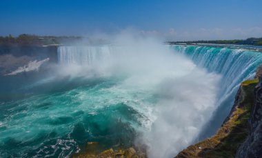 Horseshoe falls Niagara Falls Ontario kenarı üzerinde güçlü Niagara Nehri kükrüyor. Sisli puslu sprey yükselir.