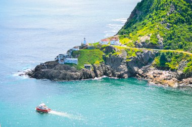 Wonderful view - summer day over the coastline and cliffs of a Canadian National Historic Site, Fort Amherst in St John's Newfoundland, Canada.  A tour boat passes through.