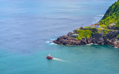 Wonderful view - summer day over the coastline and cliffs of a Canadian National Historic Site, Fort Amherst in St John's Newfoundland, Canada.  A tour boat passes through.