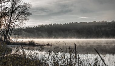 Misty Gölü gündoğumu sayısı gelen sıcak suyu serin havaya yükselen sis ile.