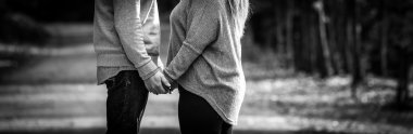 Young couple facing each other while holding hands, black and white, expressing love, clipart