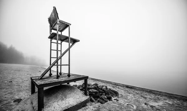 Silla de salvavidas vacía en la playa en noviembre niebla de la mañana . — Foto de Stock