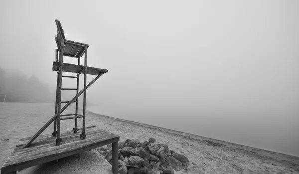 Silla de salvavidas vacía en la playa en noviembre niebla de la mañana . — Foto de Stock
