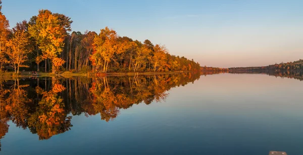 Зеркальные отражения и пылающий оранжевый лес на озере Северное Онтарио на закате солнца в конце лета . — стоковое фото