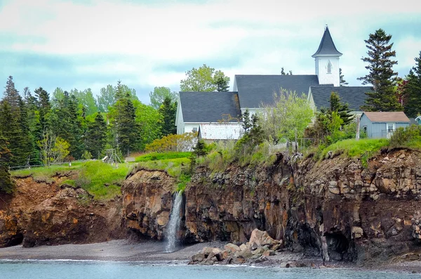 Waterfalls behind a church.  Edge of Canada at Margaretsville,  Bay of Fundy.  Low tide in Nova Scotia. — Stock Photo, Image