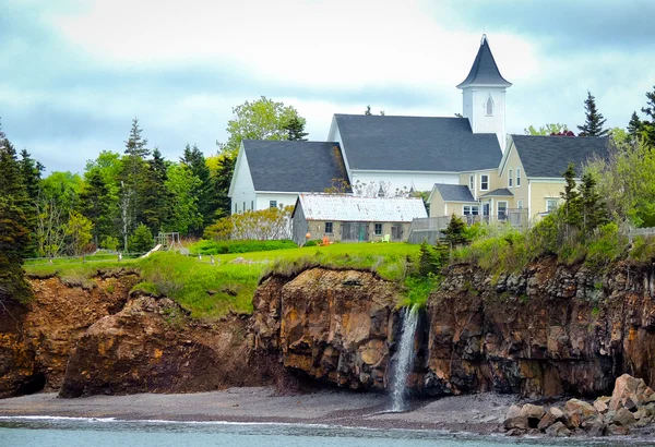 Waterfalls behind a church.  Edge of Canada at Margaretsville,  Bay of Fundy.  Low tide in Nova Scotia. — Stock Photo, Image