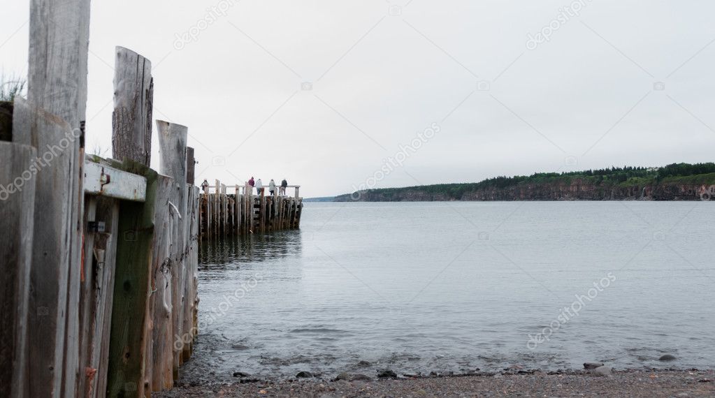 People fishing at the end of a dock in Springtime. Nova Scotia coastline in June.