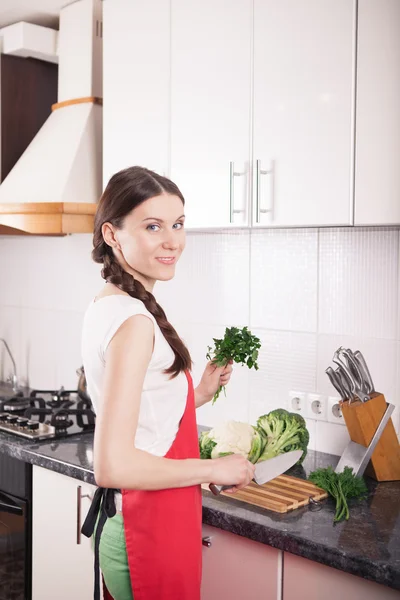 Mulher sorrindo fazendo comida saudável na cozinha . — Fotografia de Stock