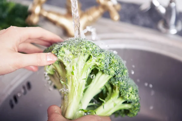 washing vegetables in sink