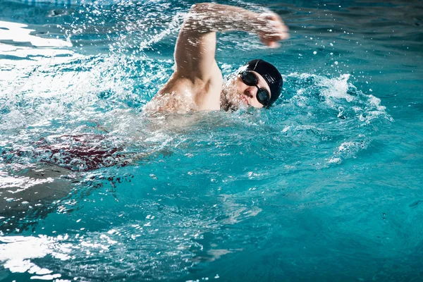 Giovane uomo che nuota davanti strisciare in una piscina — Foto Stock