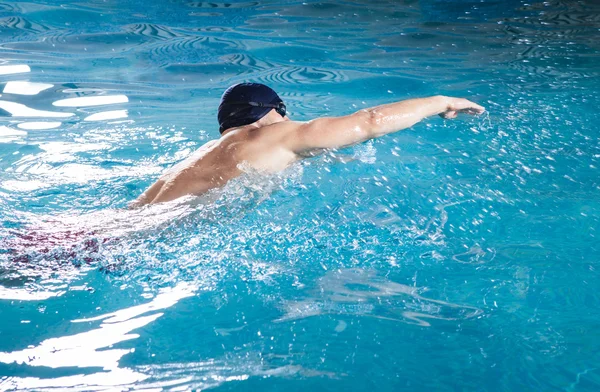 Giovane uomo che nuota davanti strisciare in una piscina — Foto Stock