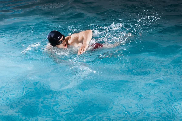 年轻男子在游泳池中游泳前爬网 — 图库照片