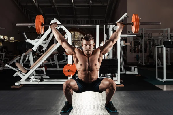 Musclé homme soulevant un haltère — Photo