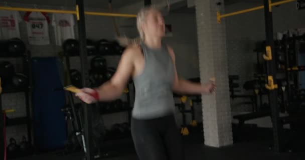 Sportswoman jumping with rope in gym — Stock Video