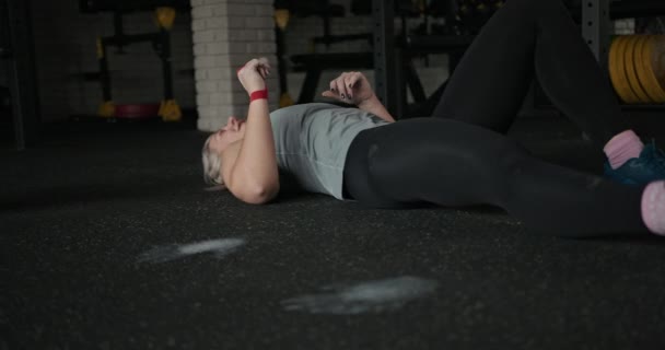 Levantamiento de pesas femenino fuerte descansando durante el entrenamiento — Vídeos de Stock