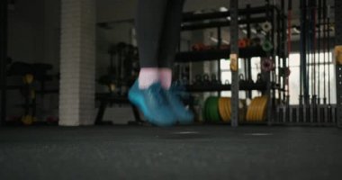 Sporcu kadın spor salonunda iple atlıyor.