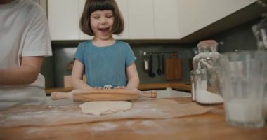 Mutfakta hamuru yuvarlayan mutlu çocuk