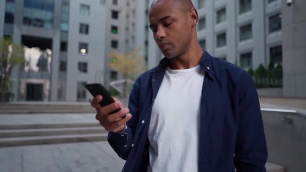 Uomo etnico utilizzando smartphone sulla strada — Video Stock