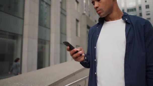 Homem étnico usando smartphone na rua — Vídeo de Stock