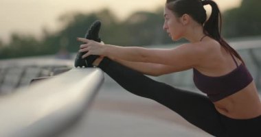 Parmaklıkların yanında ısınan sporcu kadın..