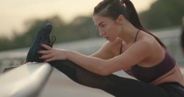 Parmaklıkların yanında ısınan sporcu kadın..