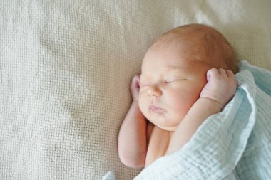 Sevimli bebek evde yatakta uyuyor.