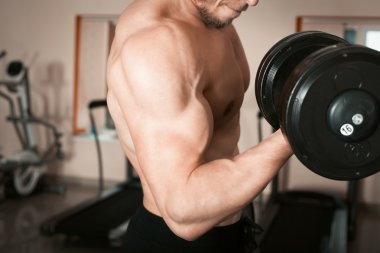 vücut geliştirmeci dumbbells ile