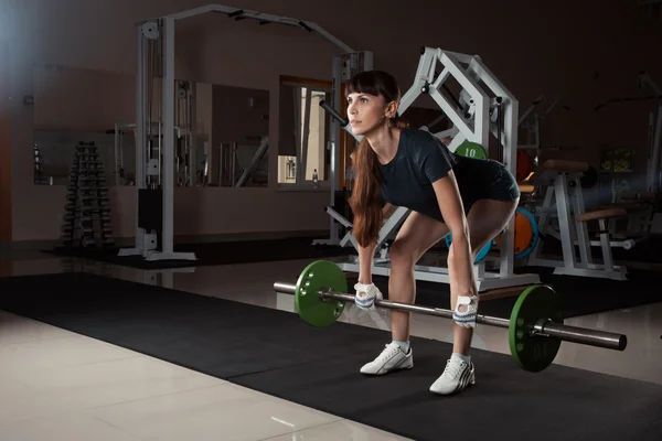 Fitness fille avec un haltère dans la salle de gym — Photo