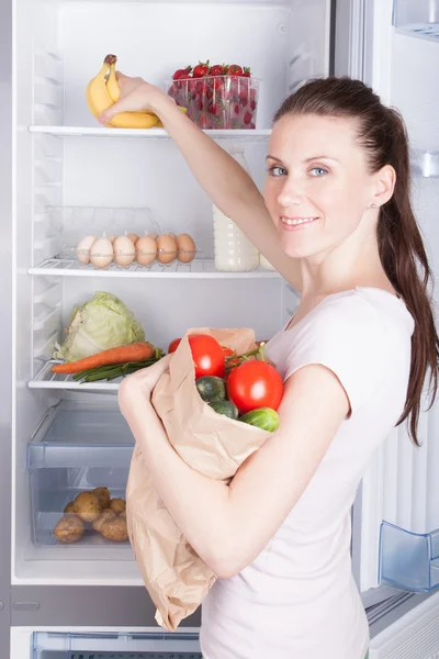 Woman near the refrigerator with healthy food. — Stock Photo, Image