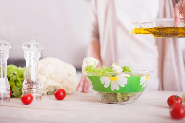 Jovem mulher mistura salada fresca. — Fotografia de Stock