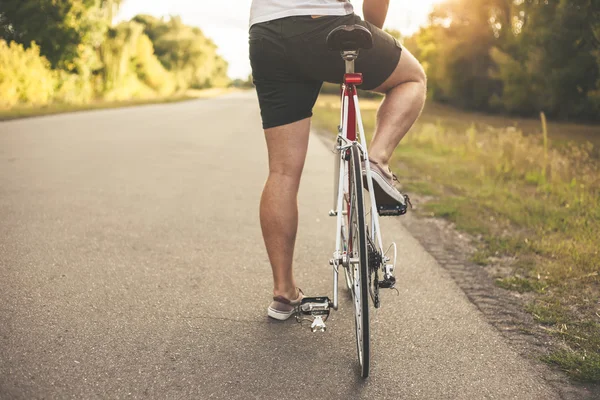 Jovem está de bicicleta — Fotografia de Stock