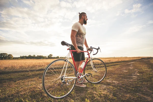 Joven hipster hombre con bicicleta — Foto de Stock