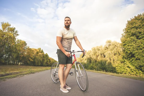 Joven hombre de estilo hipster posando con bicicleta — Foto de Stock