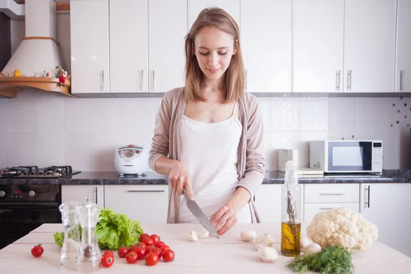 Mujer joven cocinando en la cocina. — Foto de Stock