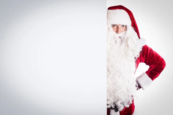 Weihnachtsmann zeigt auf weißes Blanko-Schild — Stockfoto
