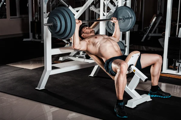 Homem muscular fazendo exercício pesado . — Fotografia de Stock