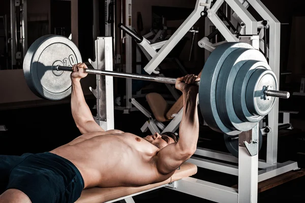 Homem muscular fazendo exercício pesado . — Fotografia de Stock