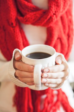 Woman hands holding a mug with hot coffee.