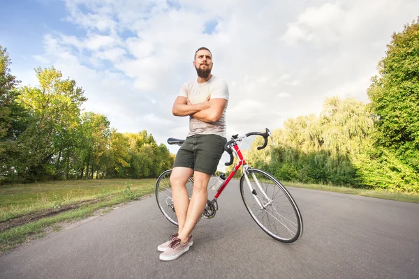 Joven hombre de estilo hipster posando con bicicleta — Foto de Stock