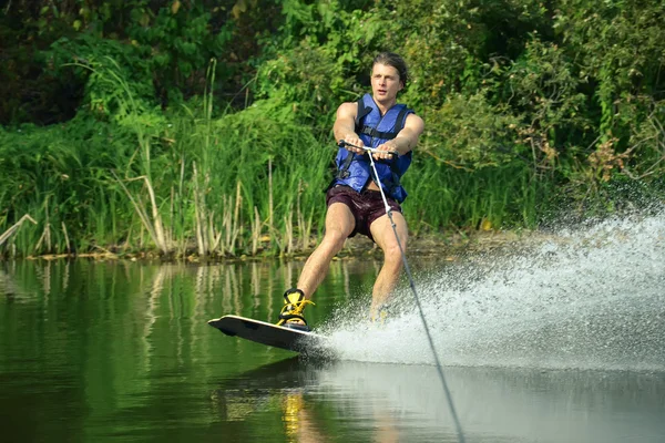 Lycklig stilig man wakesurfing i en sjö — Stockfoto